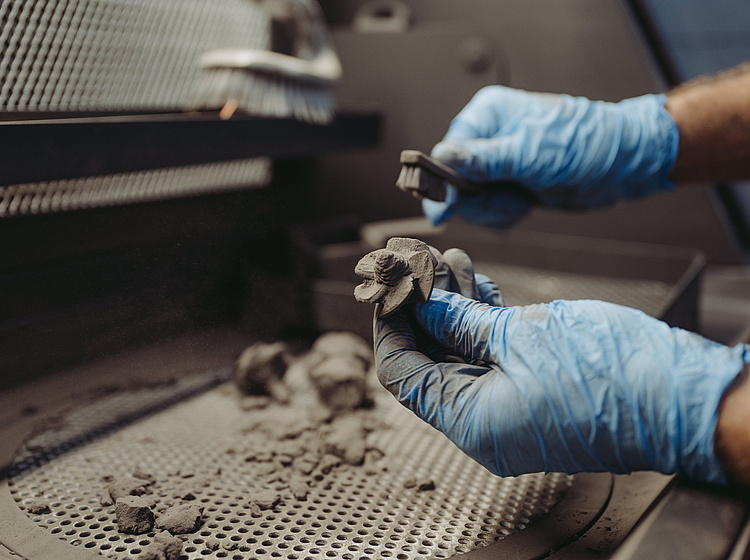 Ein Bauteil wird per Hand gesäubert 